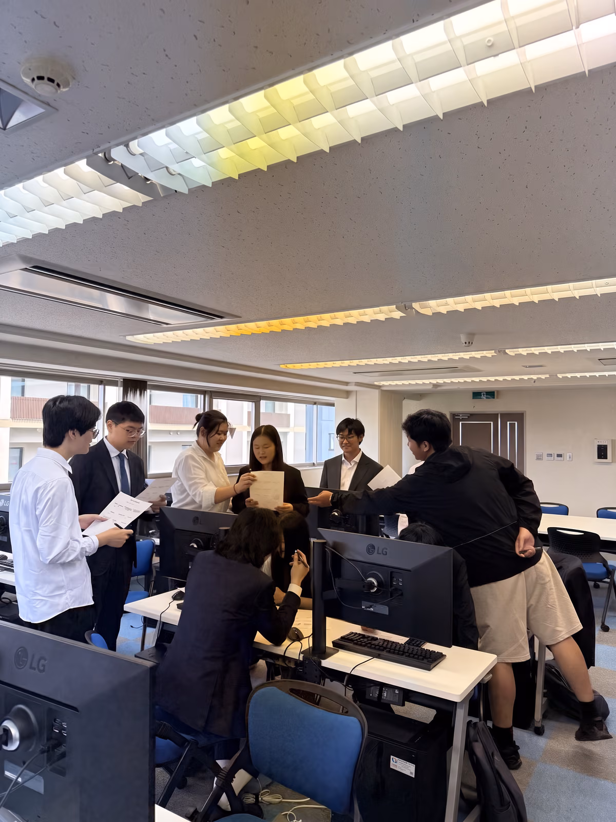 開発演習で資料を囲んで議論する参加学生